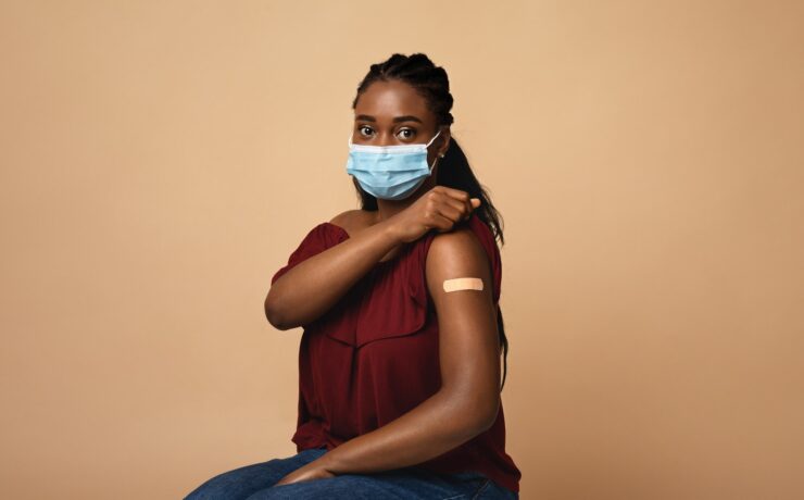 African american woman with face mask after immunization