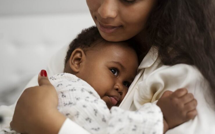 Black mother hugging her infant baby