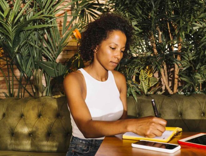 beautiful young woman writing diary wooden table