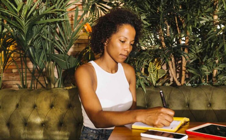 beautiful young woman writing diary wooden table